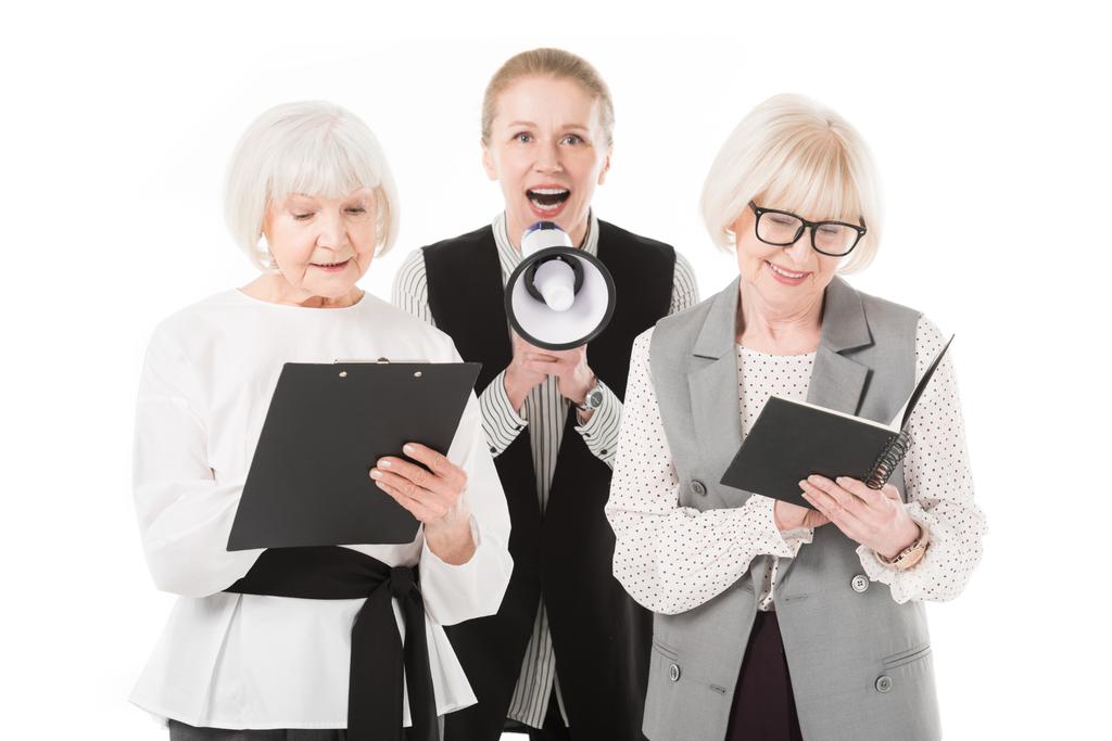 Зріла бізнес-леді з мегафоном між двома старшими бізнес-леді з буферами і підручником ізольовані на білому
 - Фото, зображення