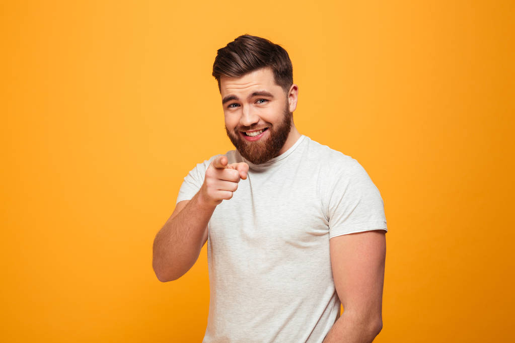 Portrait of a smiling bearded man pointing finger - Photo, Image