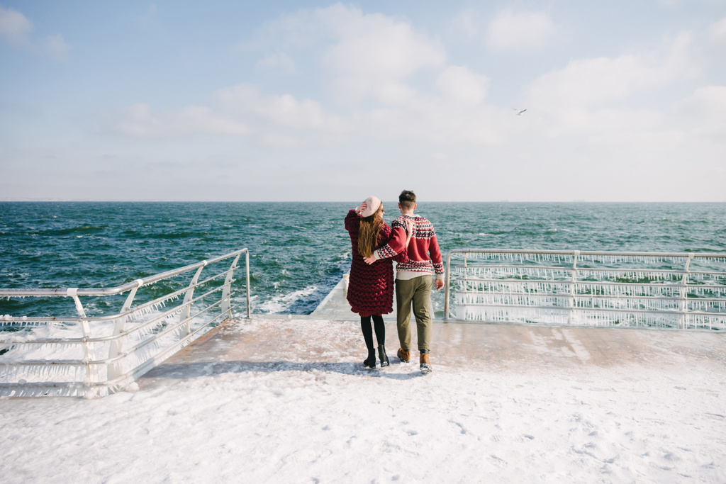 vista trasera de pareja elegante abrazándose en el muelle cerca del mar
 - Foto, imagen