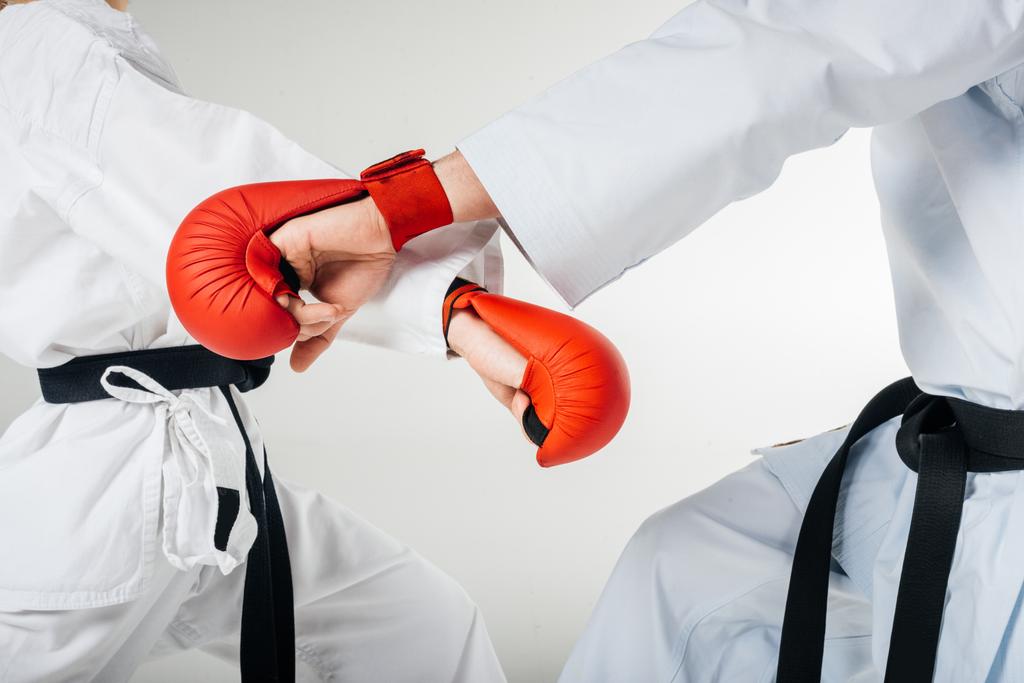 imagen recortada de combatientes de karate entrenando en guantes aislados en blanco
 - Foto, imagen