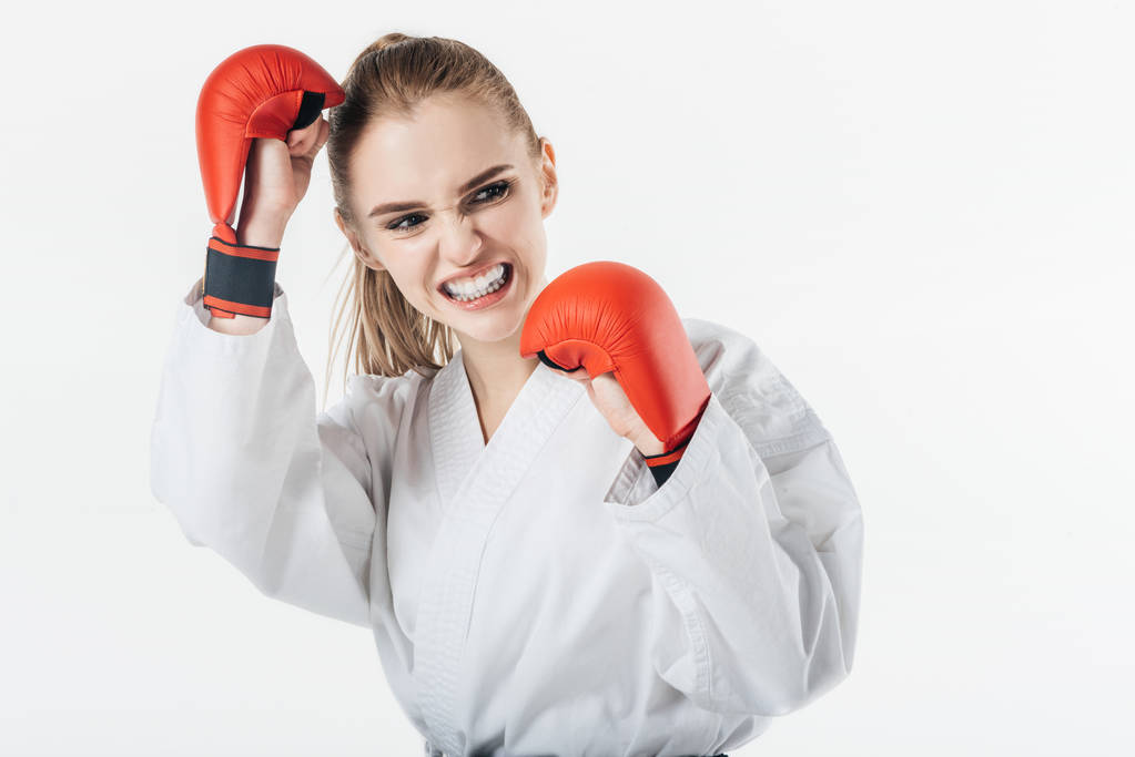 Karate-Kämpferin trainiert mit Handschuhen und Mundschutz isoliert auf weiß - Foto, Bild