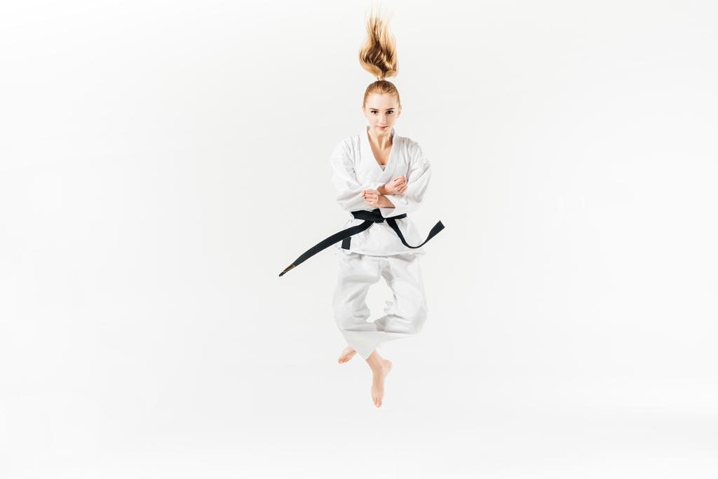 vrouwelijke karate vechter springen geïsoleerd op wit - Foto, afbeelding
