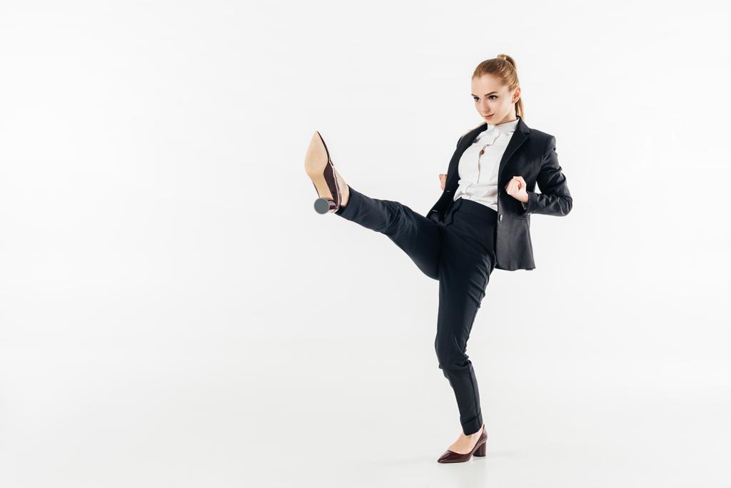 businesswoman performing karate kick in suit and high heels isolated on white - Photo, Image