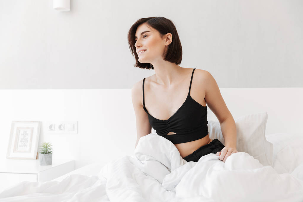 Ritratto di una bella giovane donna seduta a letto
 - Foto, immagini