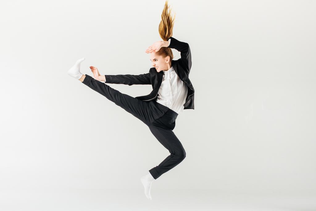 mujer karate fighter saltar y realizar patada en traje aislado en gris
 - Foto, imagen