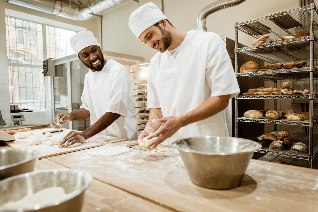 onnellinen leipurit vaivaamalla taikina yhdessä leivontaan valmistus ja puhuminen
 - Valokuva, kuva