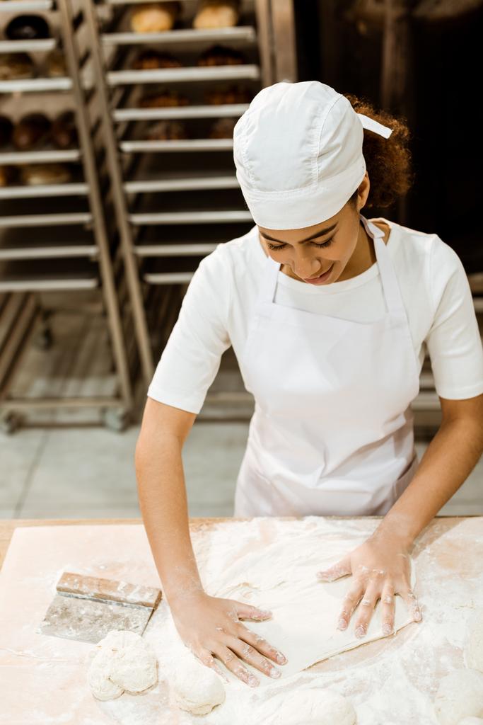 high angle view of female baker preparing dough for pastry on baking manufacture - Photo, Image
