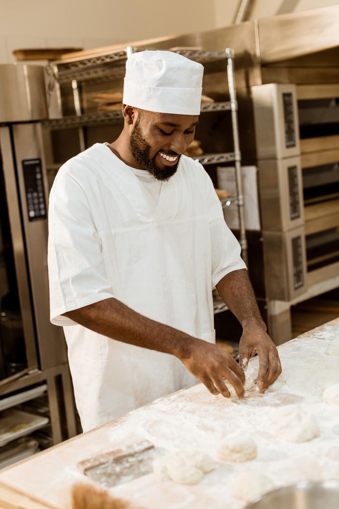 souriant afro-américain boulanger préparer la pâte sur la fabrication de cuisson
 - Photo, image