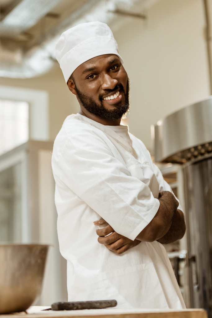 komea afrikkalainen amerikkalainen leipuri ristissä kädet katsellen kameraa leivontaan valmistus
 - Valokuva, kuva