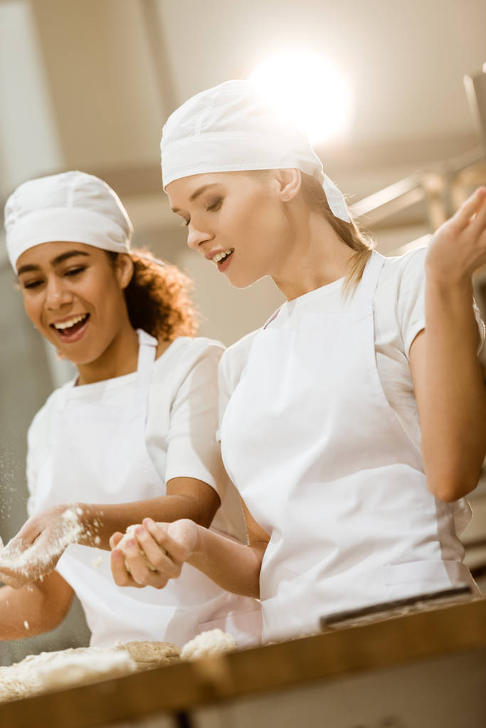 atrakcyjna kobieta piekarzy wyrabiania ciasta razem w pieczeniu produkcji - Zdjęcie, obraz