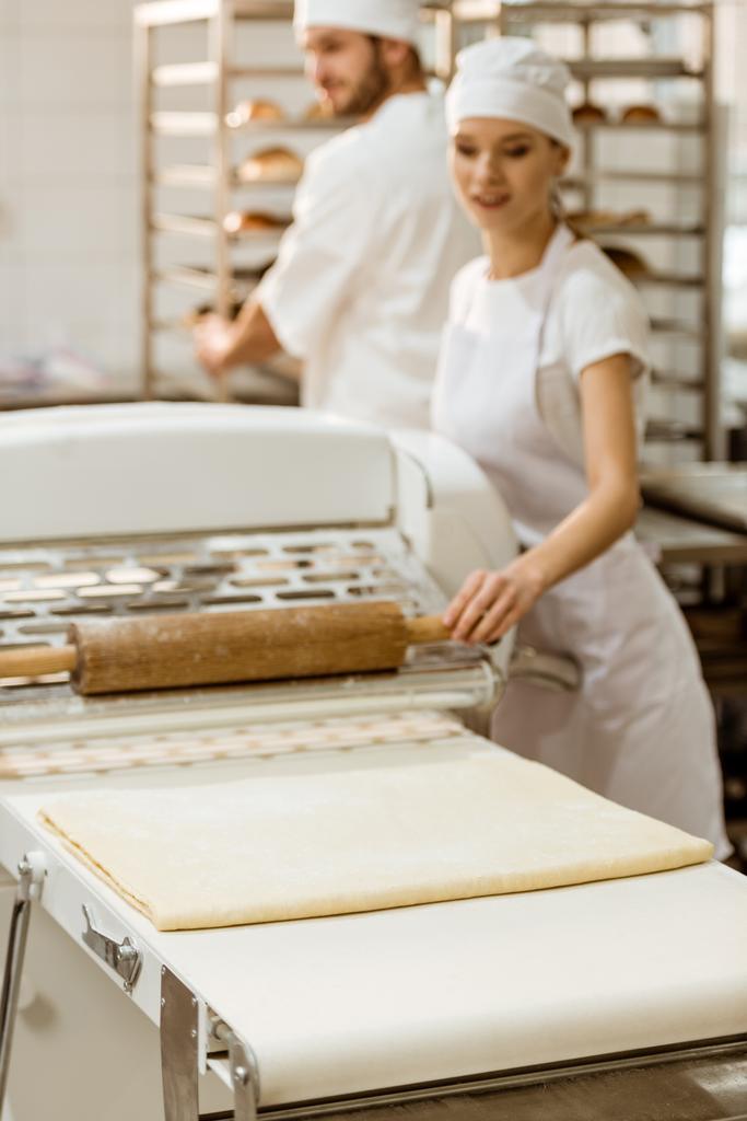 жінка-пекарня з використанням промислового тіста ролика при виробництві випічки
 - Фото, зображення