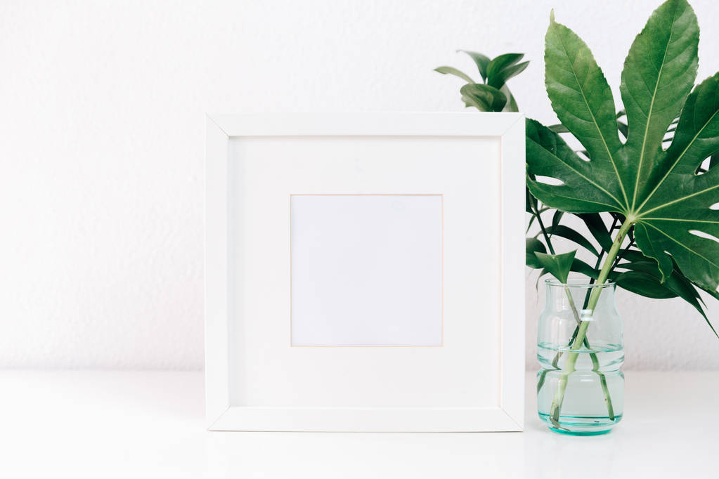Mockup minimalismo montatura bianca con foglie verdi in vaso. Arredo casa, stile nature morte
 - Foto, immagini