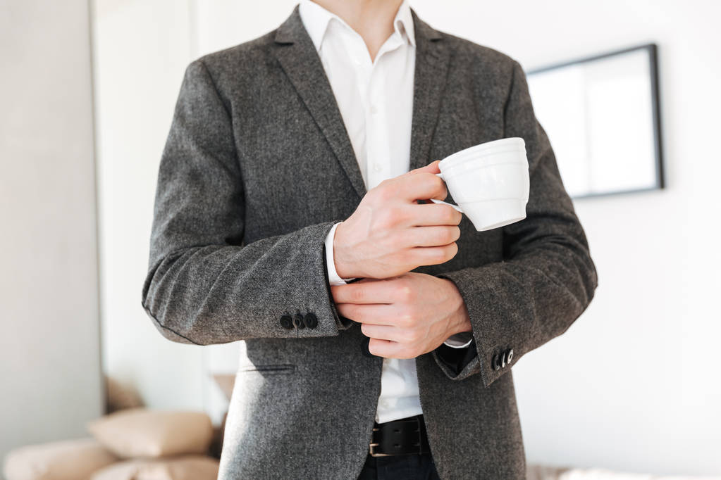 お茶のカップを保持しているビジネスの男性の画像をトリミング - 写真・画像
