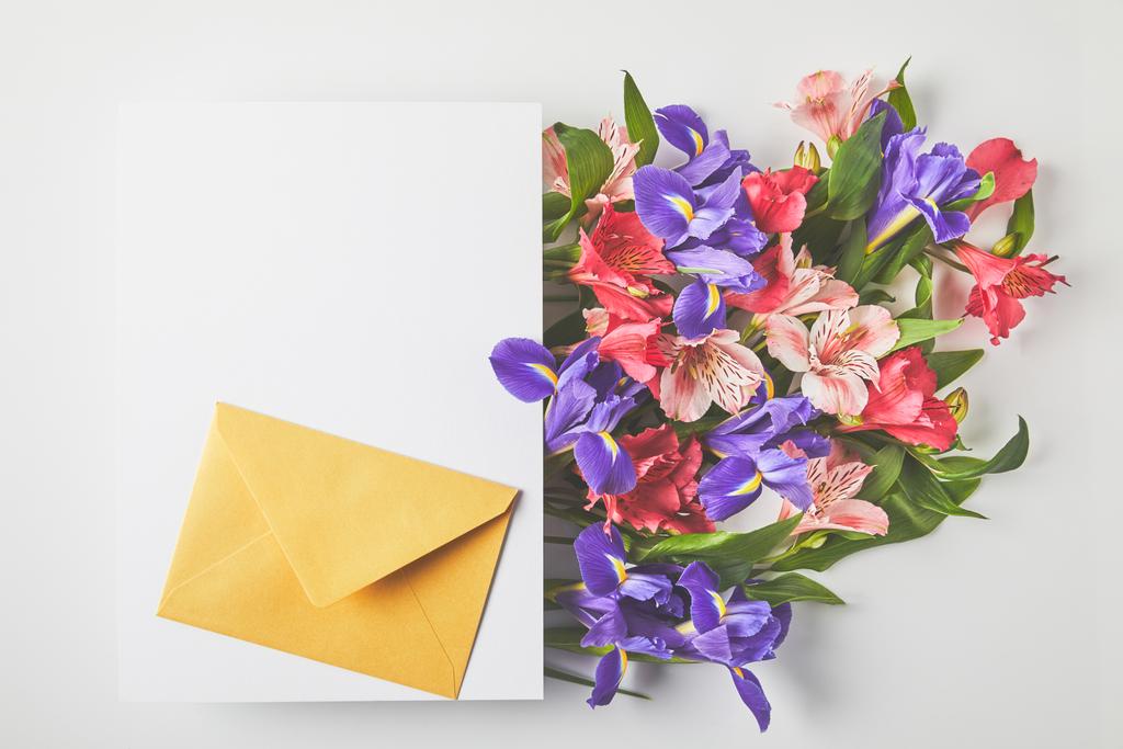 beautiful floral bouquet, blank card and envelope on grey - Photo, Image