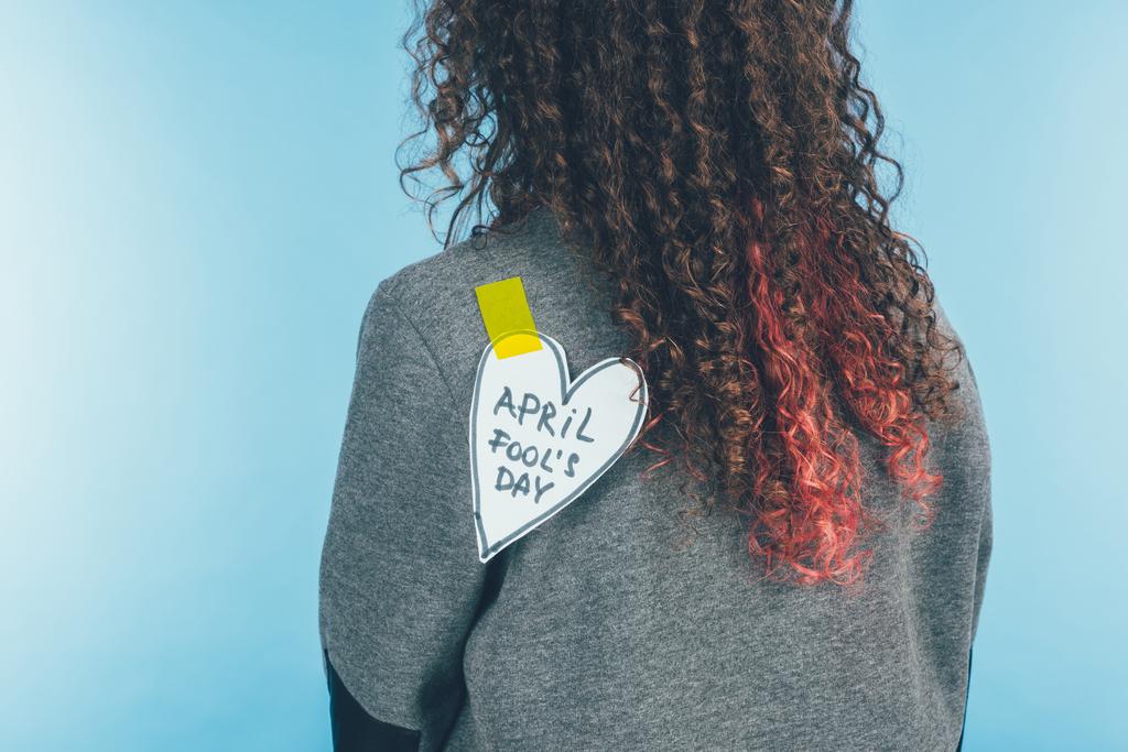 back view of woman with heart on sticky tape with april fools day lettering on back, april fools day concept - Photo, Image