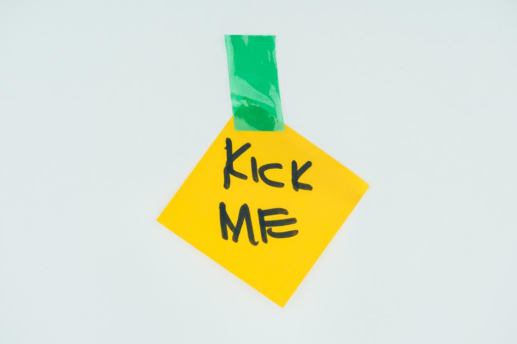 close up view of note with kick me lettering and sticky tape isolated on grey, april fools day concept - Photo, Image