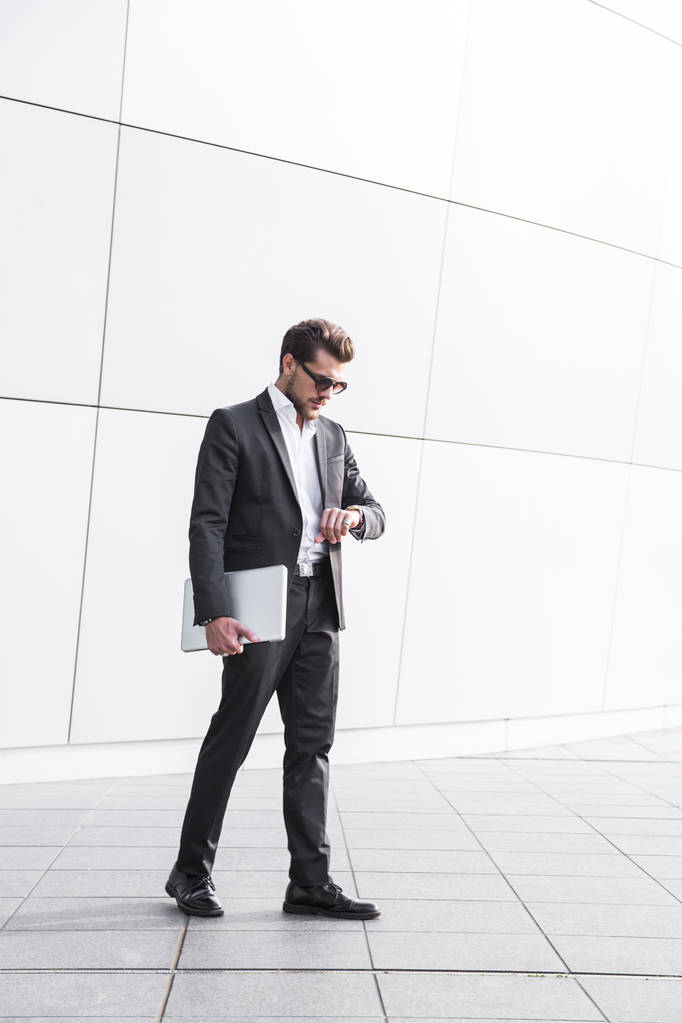 Αρσενικό επιχειρηματίας ή εργαζόμενος σε μαύρο κοστούμι με φορητό υπολογιστή - Φωτογραφία, εικόνα