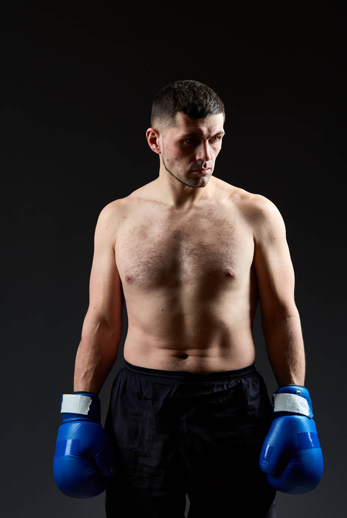 Basso ritratto chiave studio di bel combattente muscolare praticare boxe su sfondo scuro offuscata
 - Foto, immagini