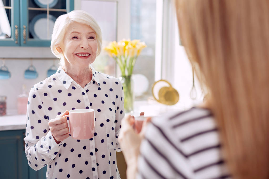 Bella donna anziana che beve caffè con sua figlia in cucina
 - Foto, immagini
