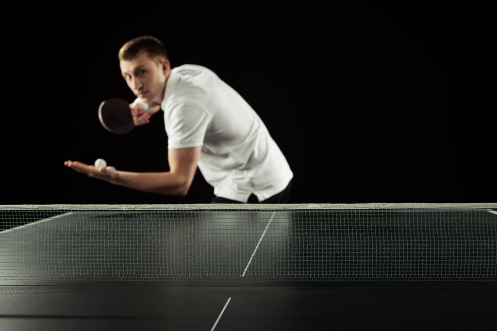 szelektív összpontosít a teniszező, teniszütő és labda kezében állt elszigetelt fekete pingpongasztal - Fotó, kép