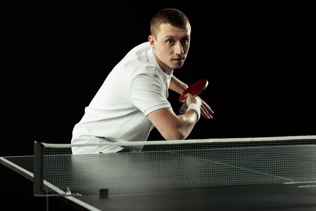 jogador de tênis concentrado jogando tênis de mesa isolado em preto
 - Foto, Imagem