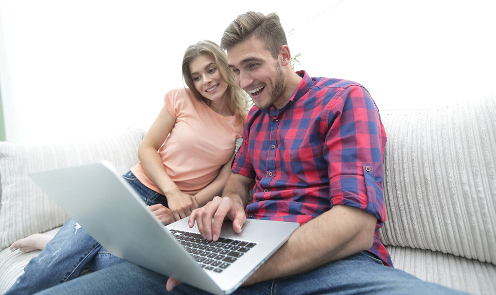 Gelukkig modern paar surfen op het net en werken aan laptop thuis - Foto, afbeelding