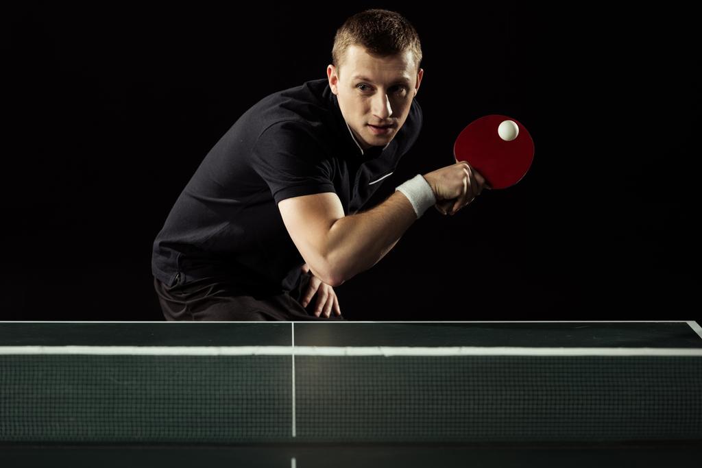 tennista concentrato che gioca a ping pong isolato sul nero
 - Foto, immagini