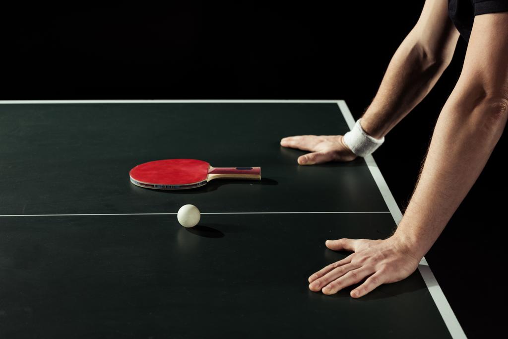 raket ve top siyah izole Tenis masanın üzerine eğilerek tenisçi kısmi görünümü - Fotoğraf, Görsel