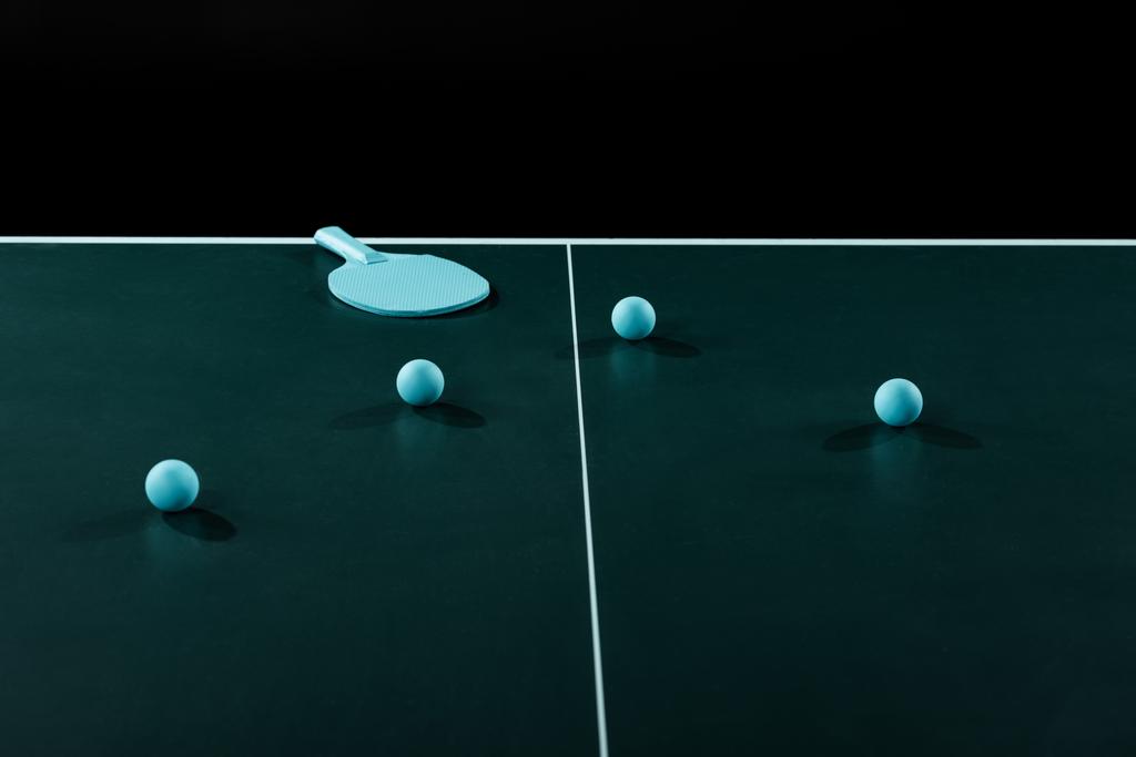 close up view of blue tennis racket and balls on tennis table isolated on black - Photo, Image