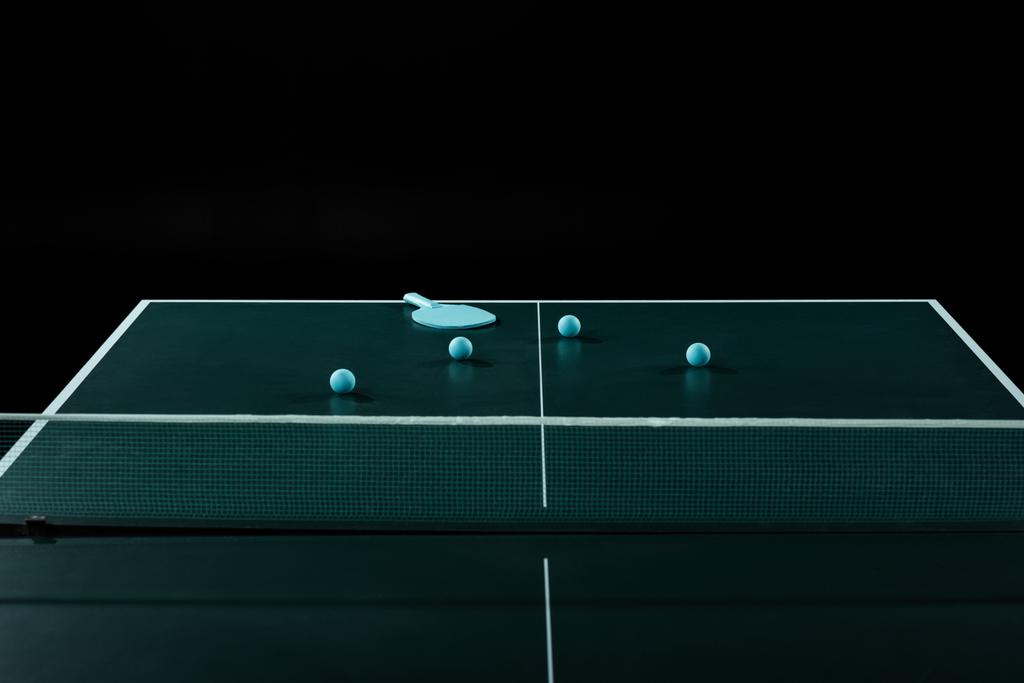 close up view of blue tennis racket and balls on tennis table isolated on black - Photo, Image