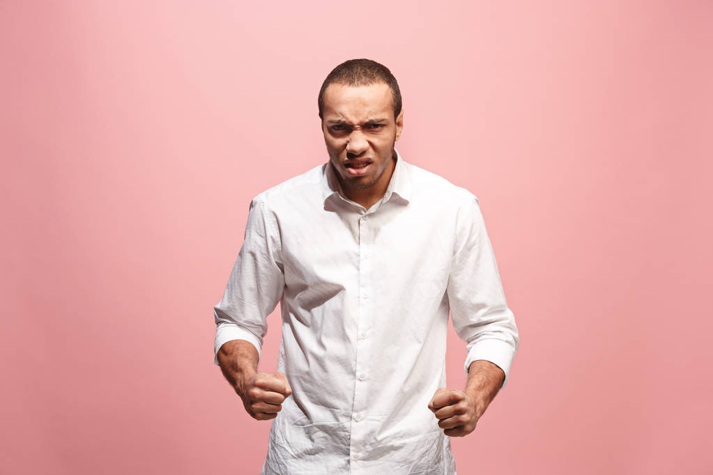 O jovem homem irritado emocional gritando no fundo do estúdio rosa
 - Foto, Imagem