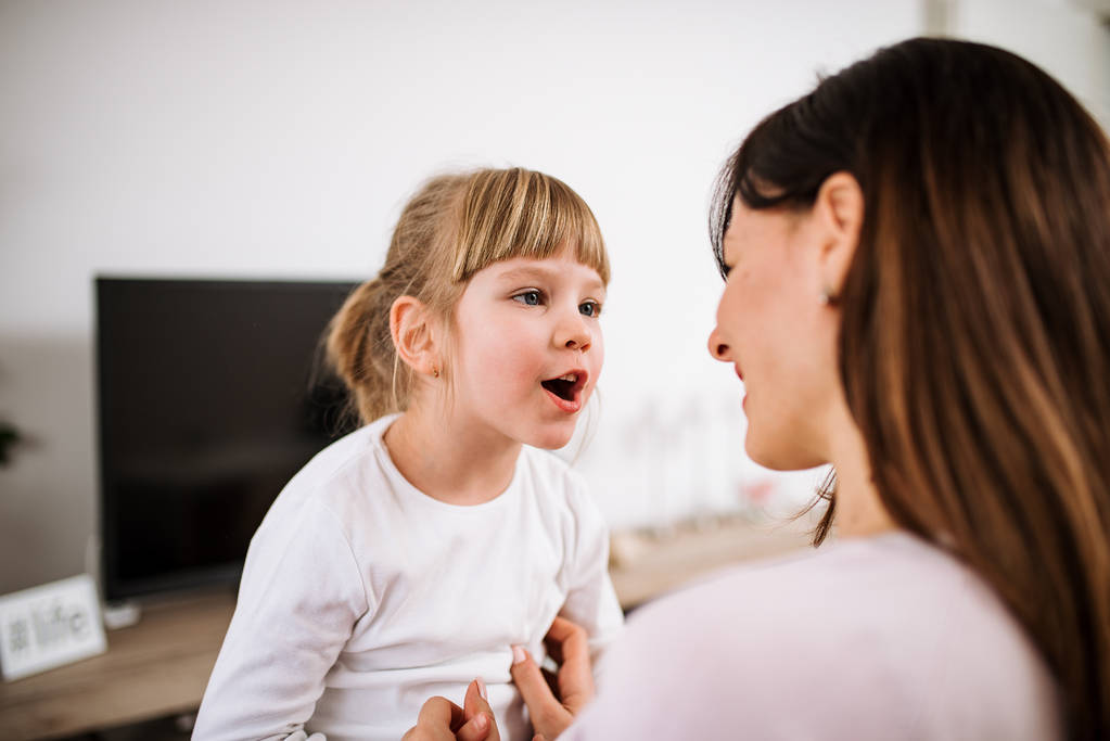 Close-up image of little girl talking with mother. - Photo, Image