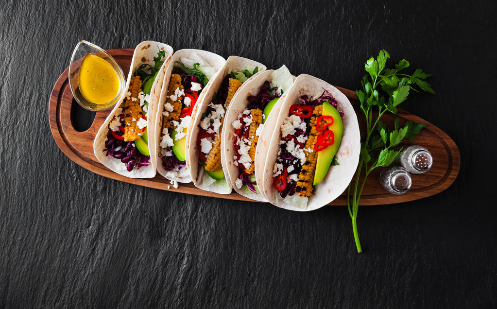 Mexicaanse taco's met avocado, geroosterde maïs, rode kool slaw en c - Foto, afbeelding