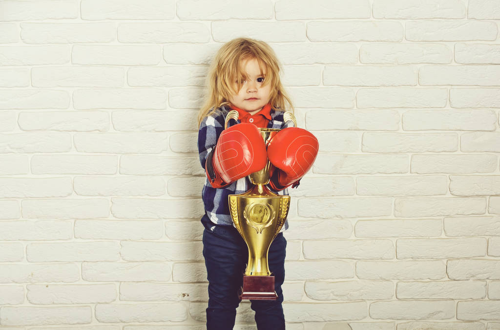子供の身に着けているボクシング グローブ少年ボクサー ゴールデン チャンピオン カップ優勝 - 写真・画像