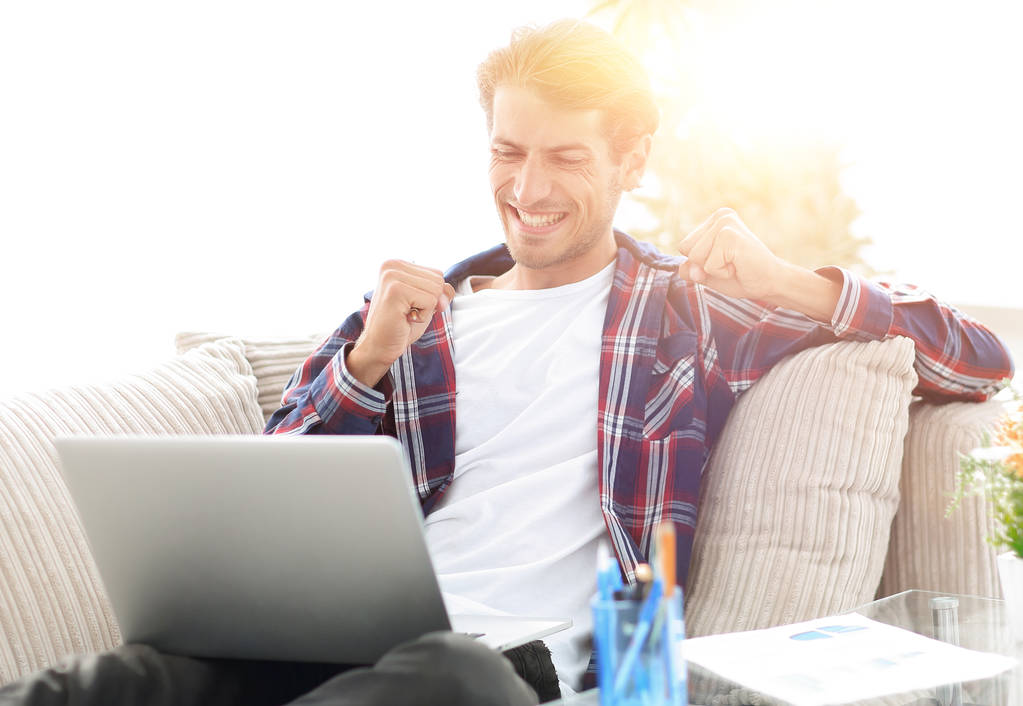 happy guy working with laptop from home. concept of freelancing. - Photo, Image