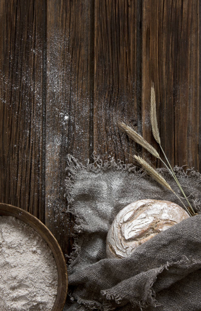 közeli kép a frissen sütött hagyományos kenyér, a liszt és a búza, a fából készült háttér - Fotó, kép