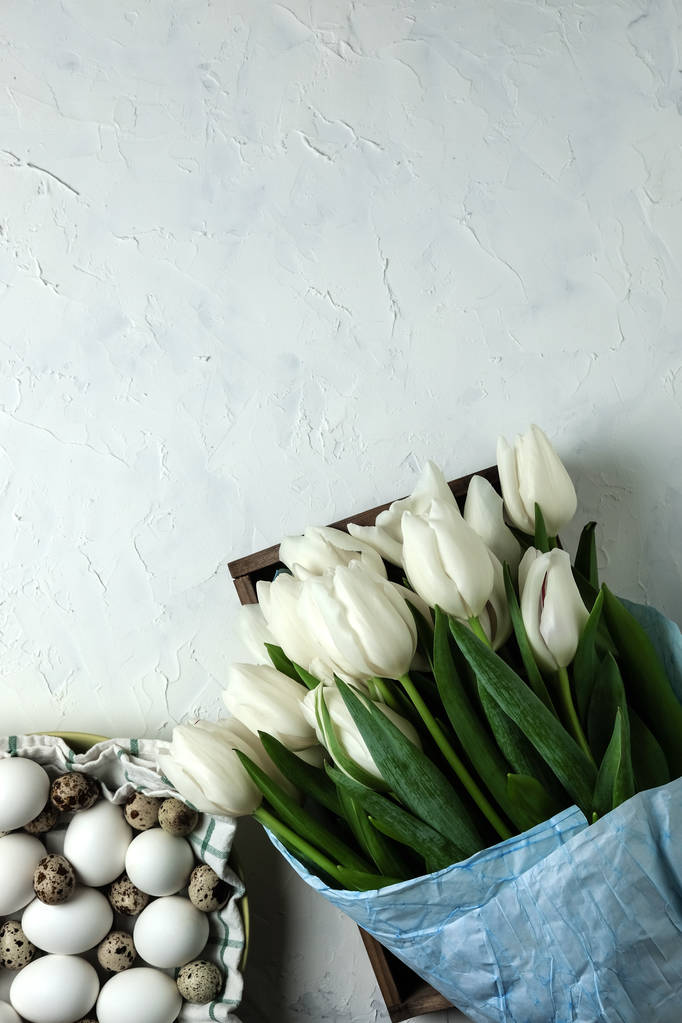 包装卵プレート紙コンクリート、白地に青の白いチューリップの花束。平面図です。フラットが横たわっていた。イースター、母の日、春休みのはがき. - 写真・画像