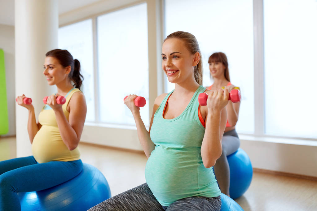 вагітні жінки тренуються з вправами в тренажерному залі
 - Фото, зображення