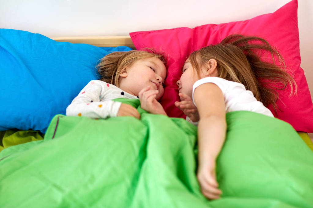 joyeuses petites filles dormant au lit à la maison
 - Photo, image