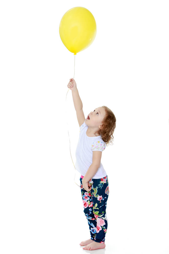Маленькая девочка играет с воздушным шаром - Фото, изображение