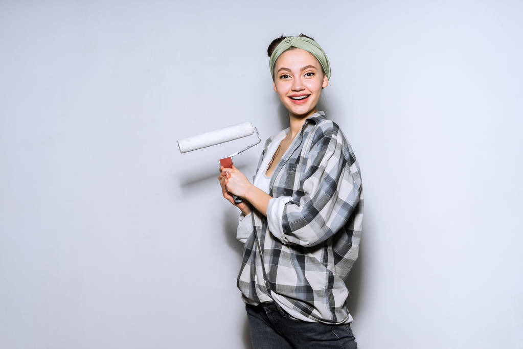 kadın bir duvar boyası için hazırlık gri arka plan üzerinde - Fotoğraf, Görsel
