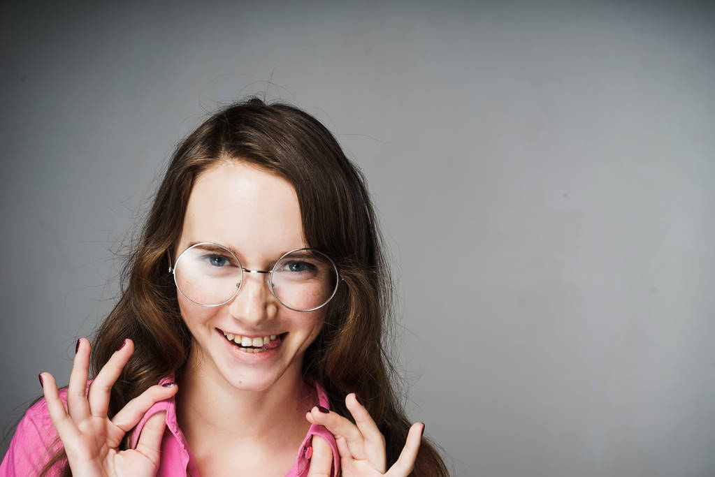 γυναίκα εργαζόμενος σε ένα ροζ πουκάμισο και τα γυαλιά που χαμογελά - Φωτογραφία, εικόνα
