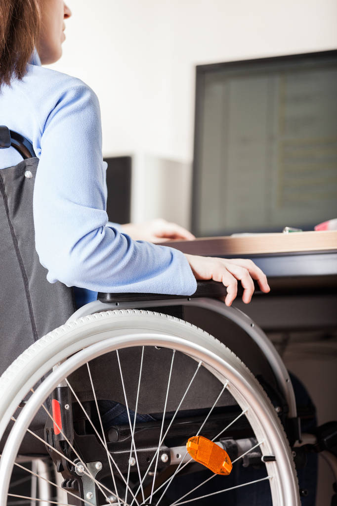 Инвалид или женщина-инвалид, сидящая в инвалидной коляске, рабочий настольный компьютер
 - Фото, изображение