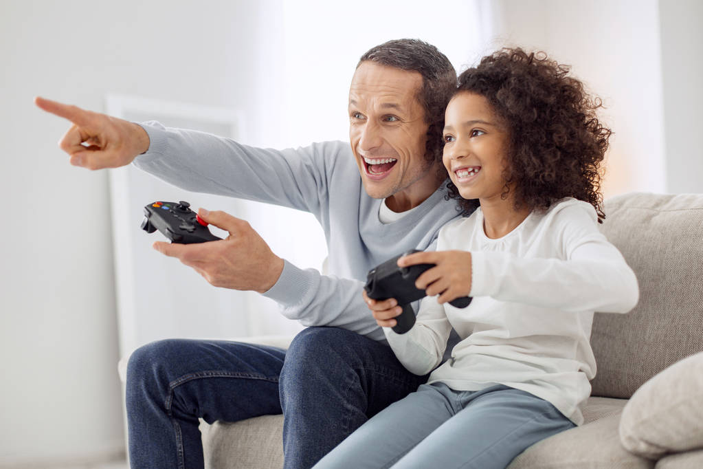 Iloinen tytär ja isä pelaa peliä
 - Valokuva, kuva