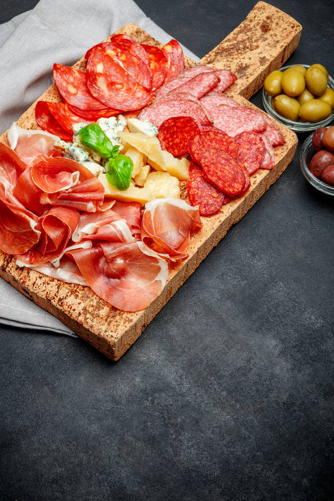 Italialainen prosciutto crudo tai espanjalainen jamon, juusto ja oliivit
 - Valokuva, kuva