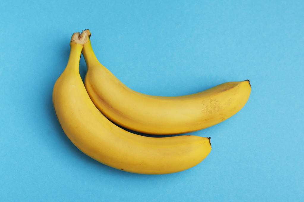 par de bananas maduras no fundo azul
 - Foto, Imagem