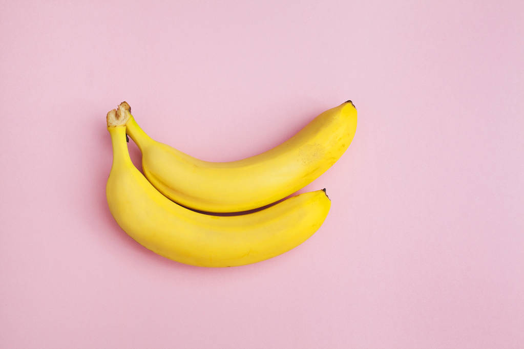 dos plátanos frescos sobre un fondo rosa aislado
 - Foto, Imagen