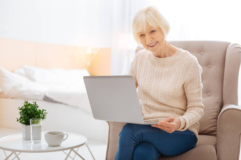 Positiivinen progressiivinen eläkeläinen nykyaikaisella kannettavalla tietokoneella ja onnellisena
 - Valokuva, kuva