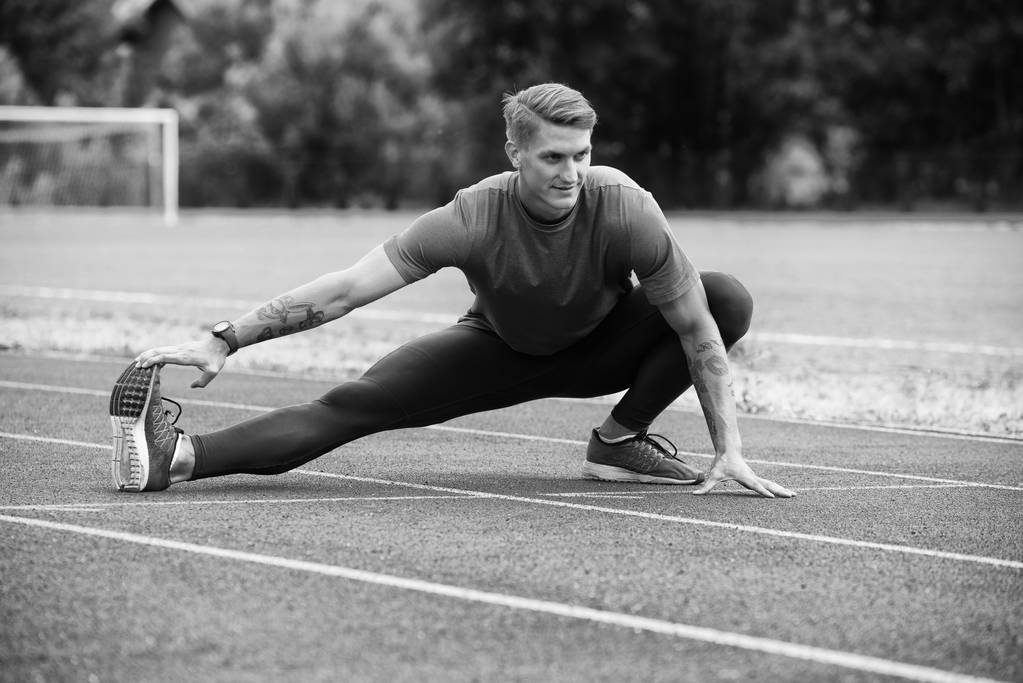 Junger athletischer Mann dehnt sich vor Lauftraining - Foto, Bild
