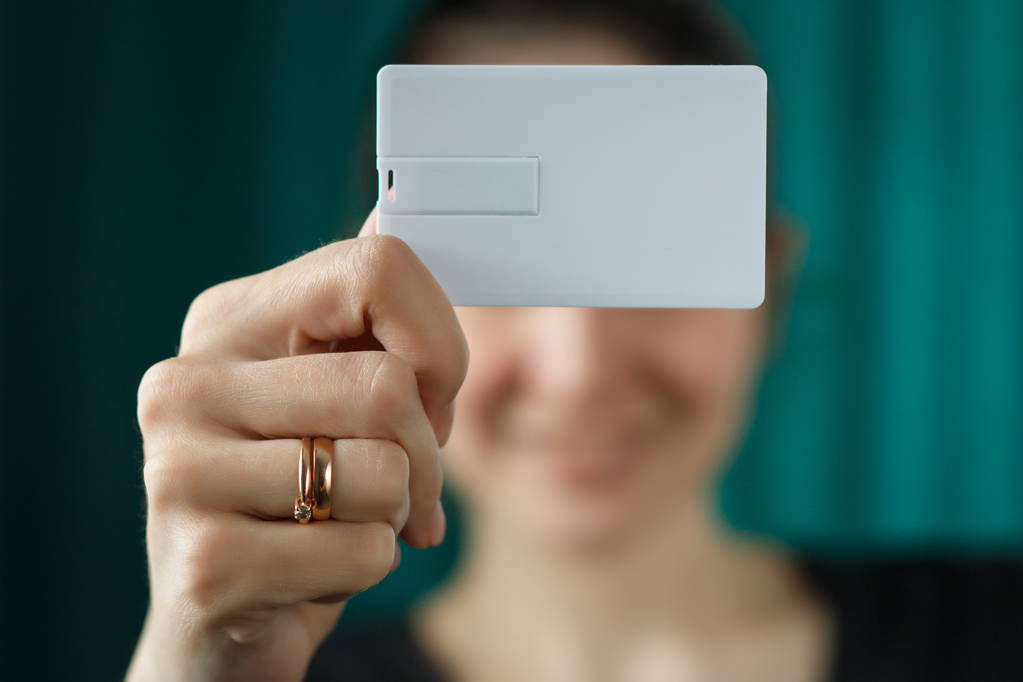 mulher segurando usb flash bussines modelo de cartão simular, papel cartão de identidade em branco para o negócio, foco seletivo
 - Foto, Imagem